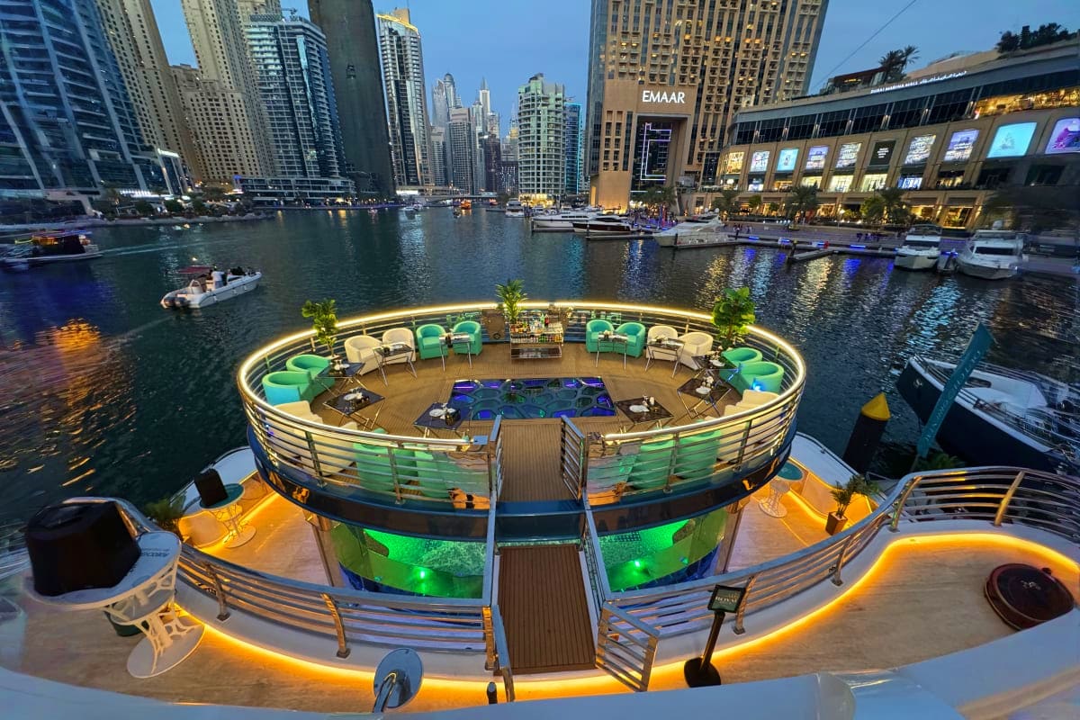 Lotus Mega Yacht Dinner Cruise Lotus Mega Yacht deck with turquoise lounge chairs overlooking Chicago River, downtown skyscrapers, and moored boats at dusk