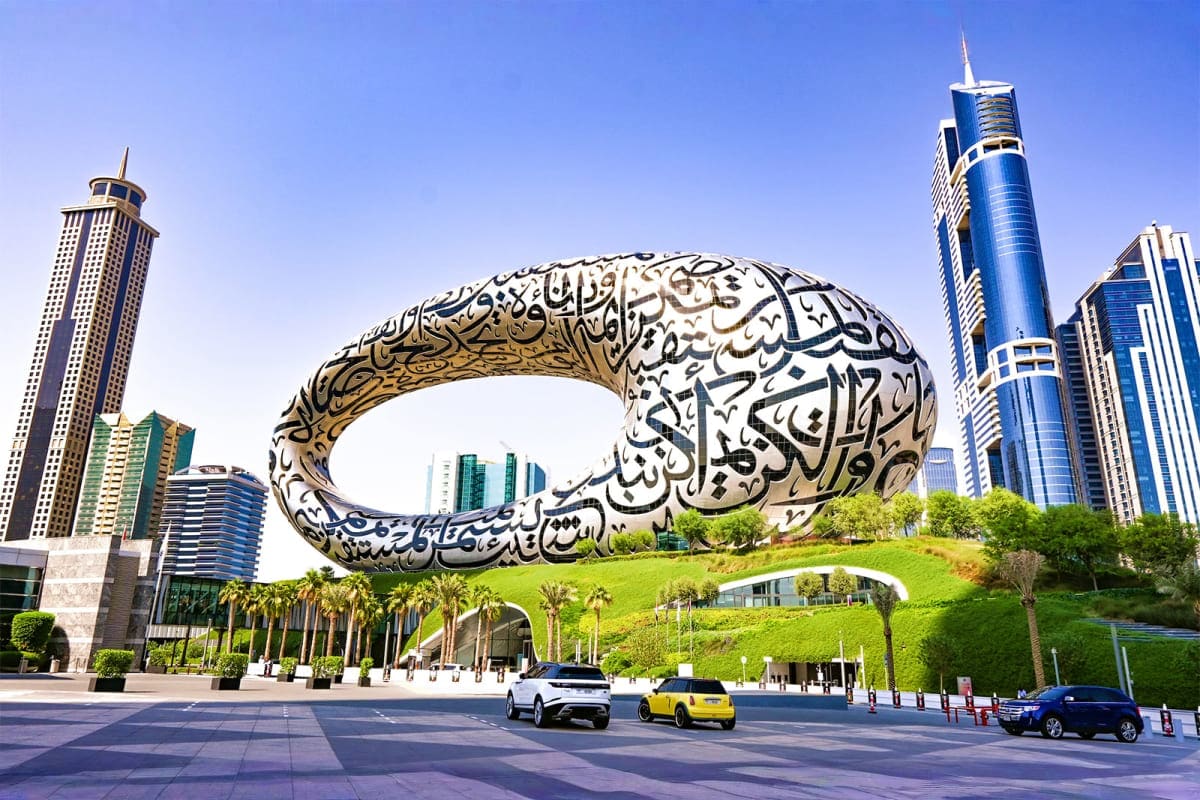 Museum of the Future iconic metallic torus sculpture with Arabic calligraphy in Dubai's modern skyline with high-rise buildin