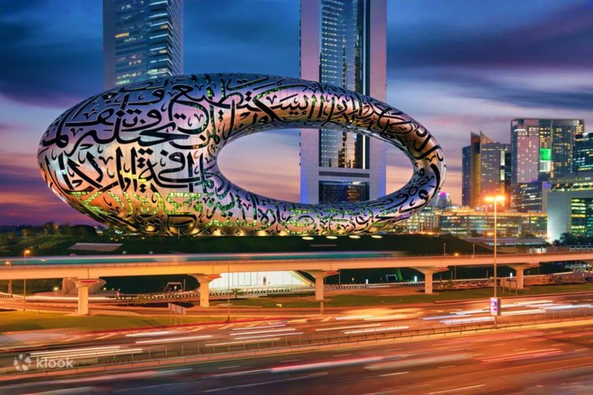 Museum of the Future Museum of the Future illuminated sculpture with Arabic calligraphy at dusk, Dubai skyline with modern high-rise buildings in