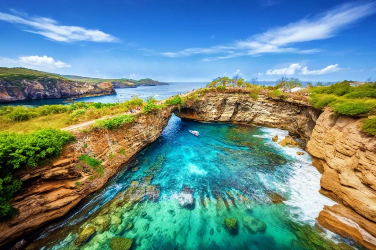 Nusa Penida Day Tour from Bali Turquoise waters and limestone cliffs at Broken Beach, Nusa Penida island in Bali with boat and green vegetation