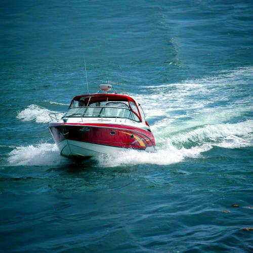Red and white speedboat navigating through blue ocean waves near Phi Phi Island