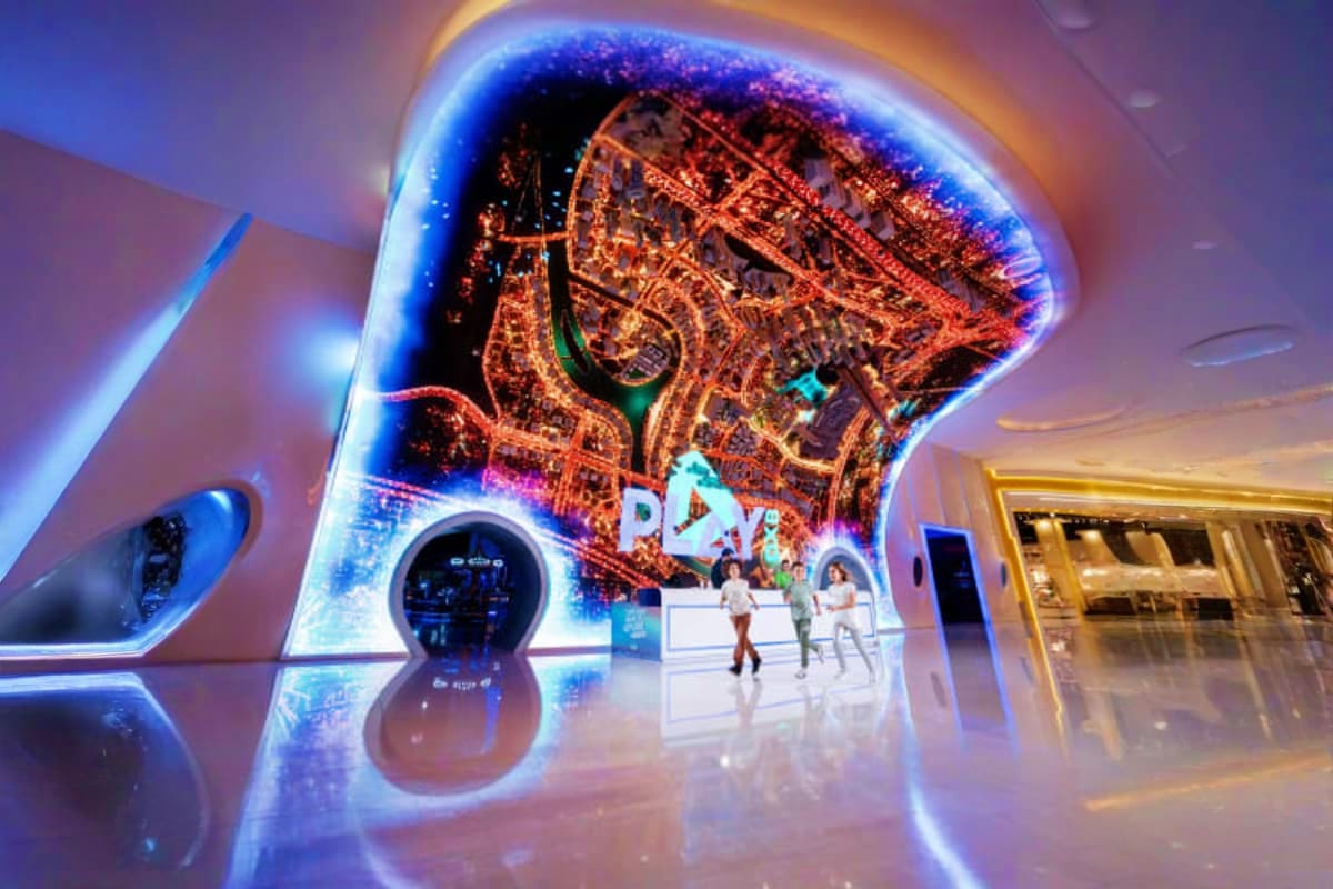 Interactive digital display showing Dubai aerial map with blue neon lighting and visitors exploring Play DXB entertainment ve