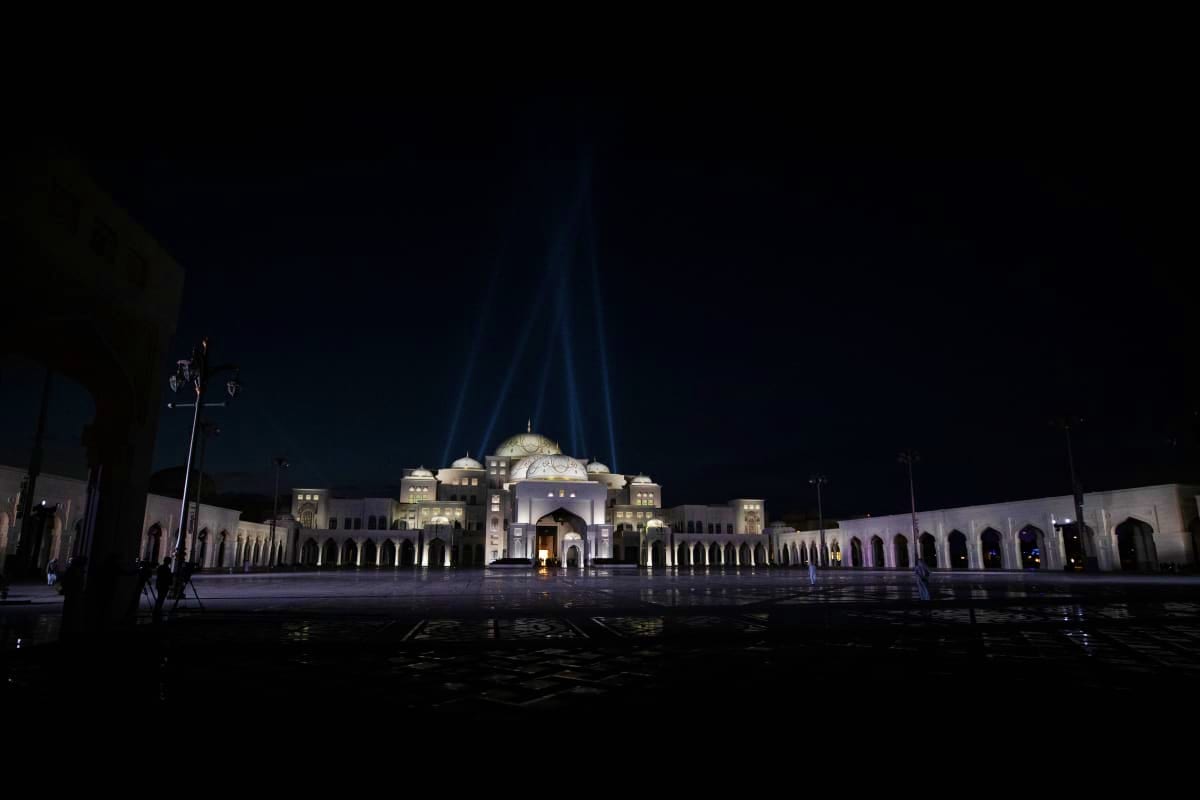Qasr Al Watan palace illuminated at night with dramatic lighting and reflection in courtyard water, Abu Dhabi