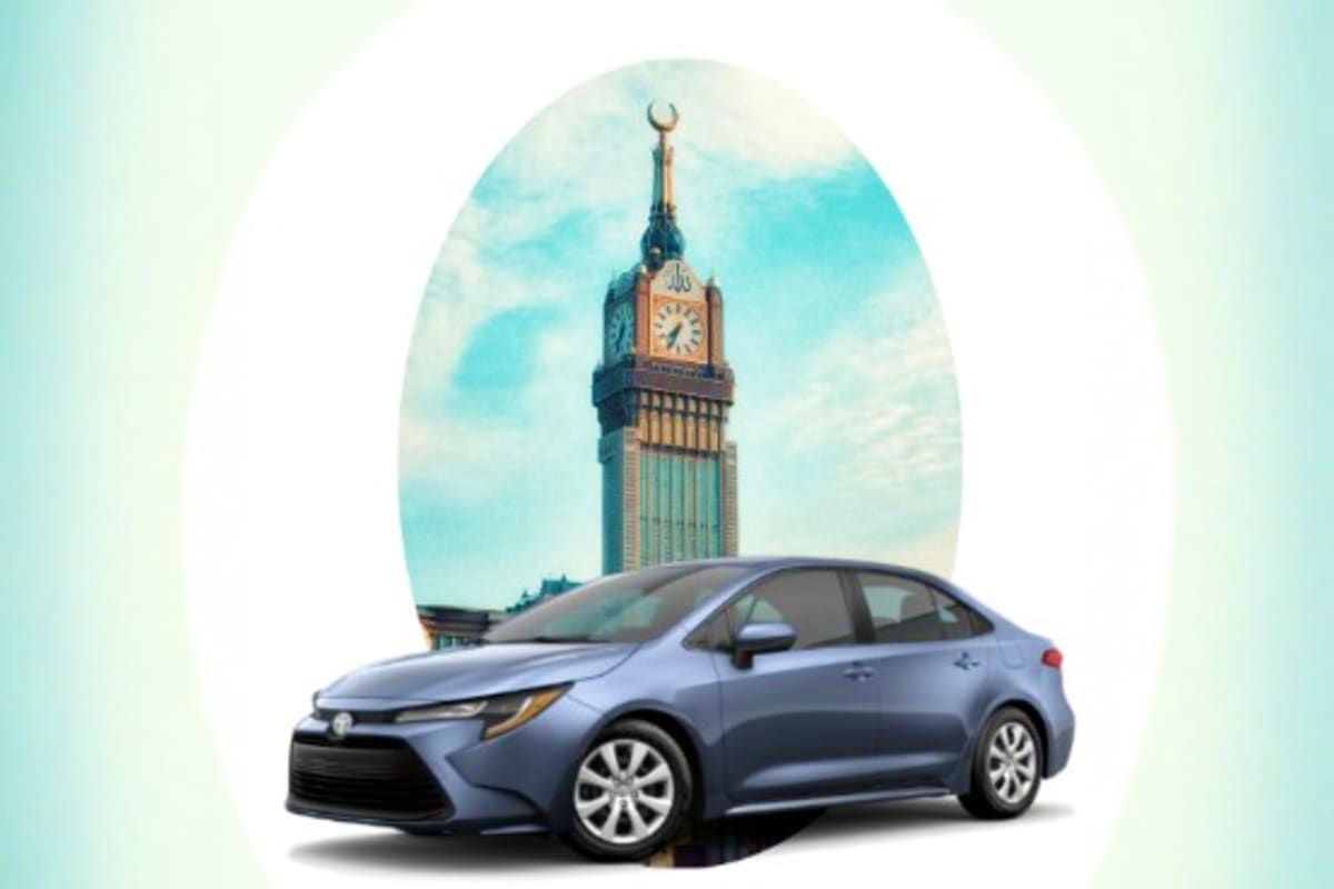 Blue sedan parked in front of an ornate clock tower with crescent moon finial against blue sky