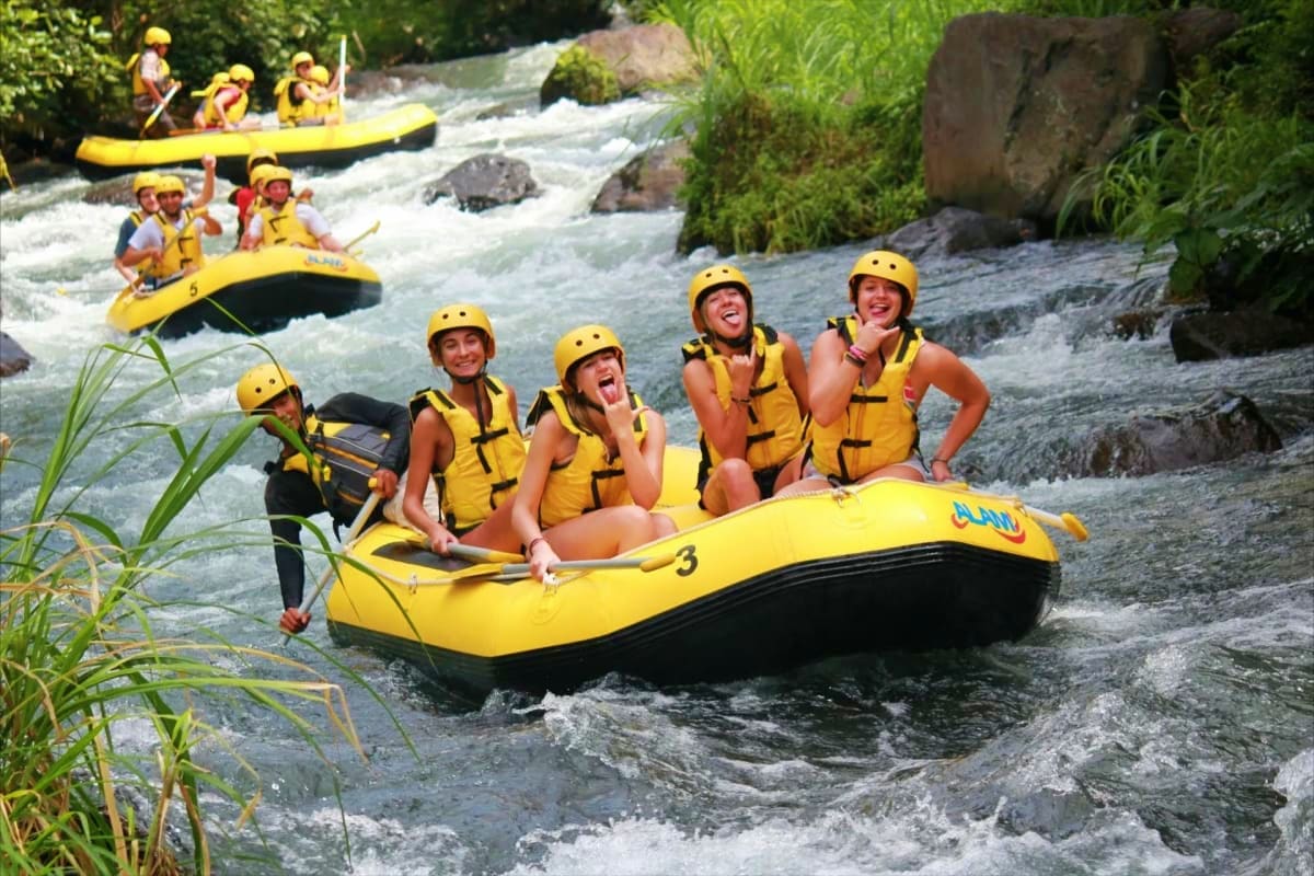 River Ayung Rafting and ATV Group of people whitewater rafting on River Ayung in yellow inflatable raft wearing helmets and life jackets