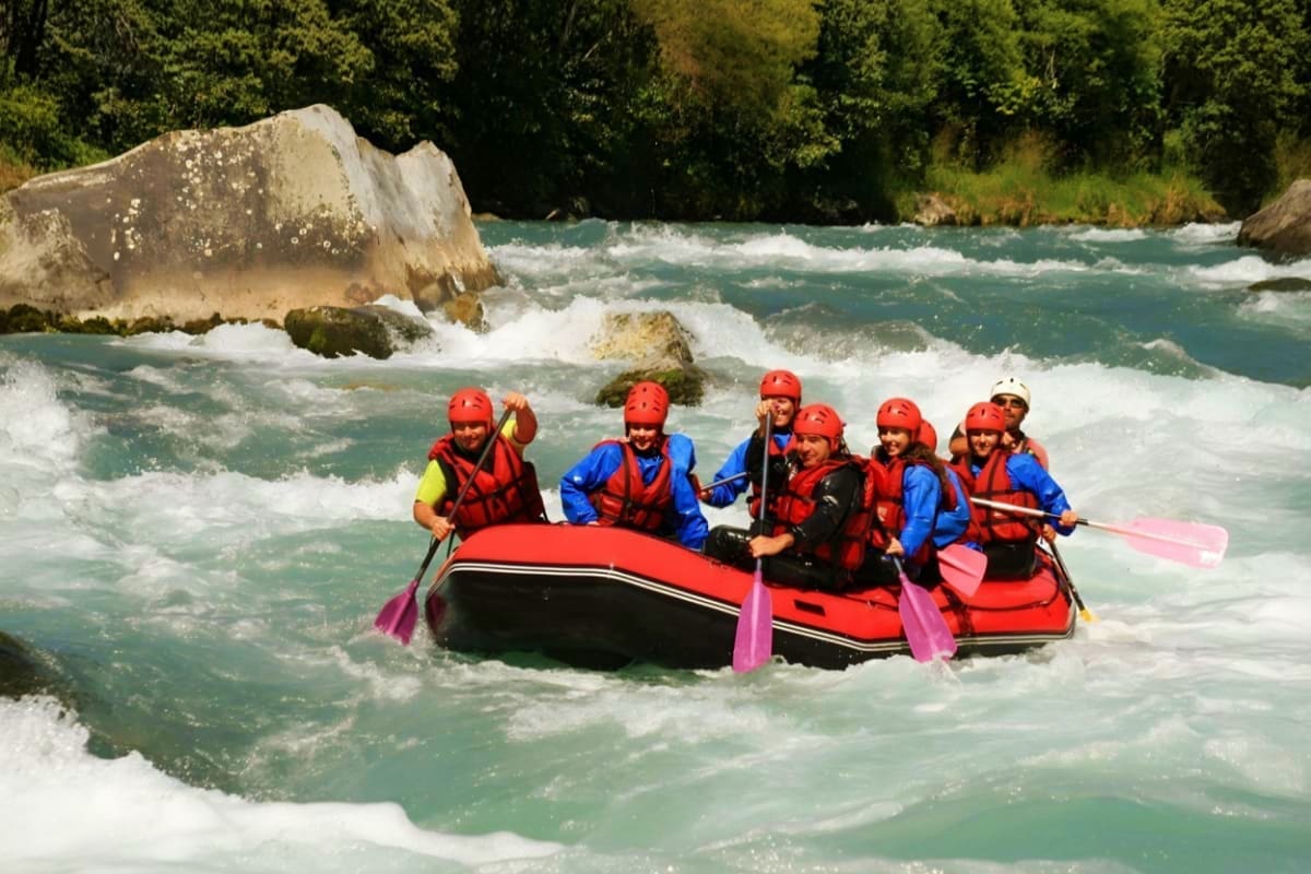 River Ayung Rafting and ATV Group of six people whitewater rafting on River Ayung with turquoise rapids and rocky riverbank surrounded by lush green fore