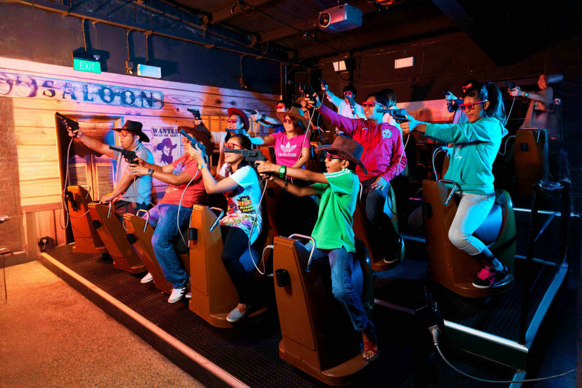 Group of visitors playing laser tag game at Sentosa 4D AdventureLand with Western saloon themed decor and neon lighting