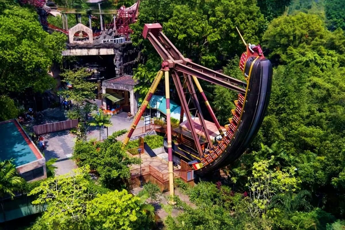 Aerial view of Junjung River Ride roller coaster at Sunway Lagoon theme park surrounded by lush green trees and water feature