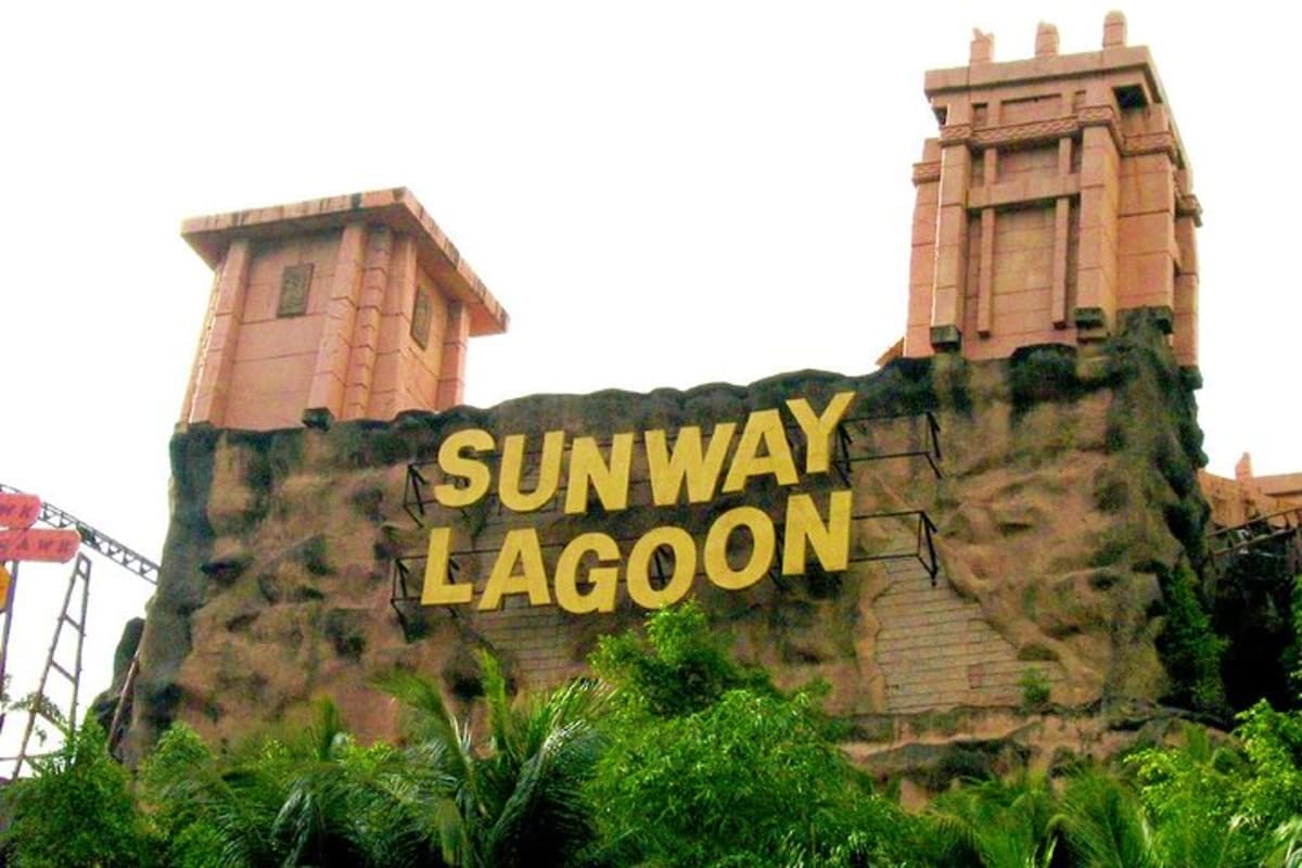 Sunway Lagoon theme park entrance sign with distinctive castle towers and rock facade surrounded by tropical vegetation