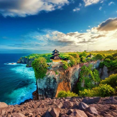 Uluwatu Temple perched on dramatic clifftop overlooking turquoise ocean waters in Bali, Indonesia
