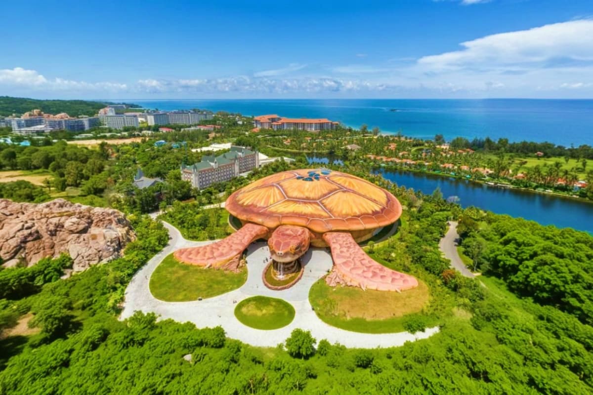VinWonders Grand Park Ho Chi Minh Aerial view of giant sea turtle sculpture at VinWonders Grand Park with resort buildings and blue coastline in background