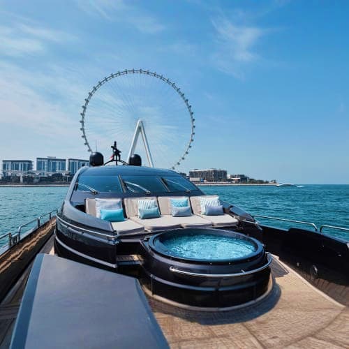 Luxury yacht deck with hot tub and seating, London Eye ferris wheel visible across Thames River water