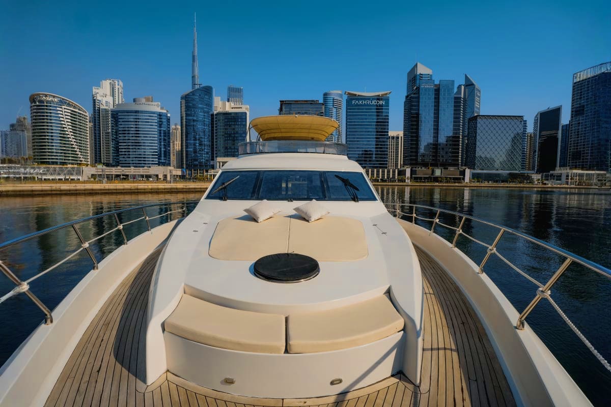 Luxury white Gold X43 yacht docked on river with Melbourne city skyline in background under clear blue sky
