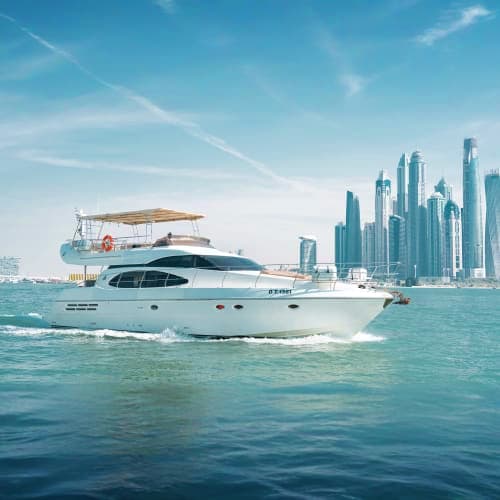 Luxury white motor yacht cruising in turquoise waters with modern skyscrapers and city skyline in background