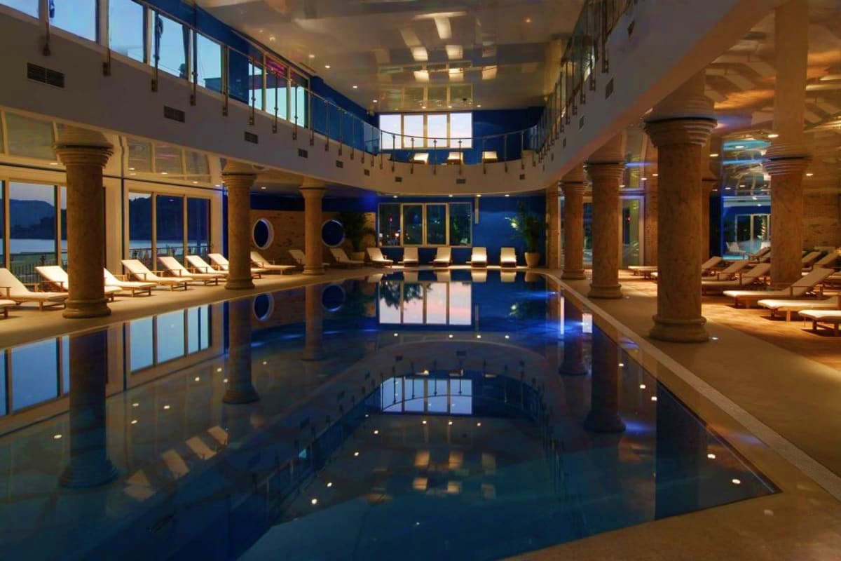 MSC Splendida South America Journey Luxurious indoor swimming pool with columns, lounge chairs, and blue-lit water on MSC Splendida cruise ship