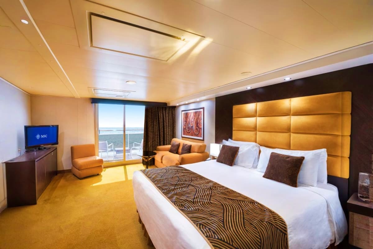 MSC Seaview South America Voyage Luxurious cruise ship cabin with ocean view, queen bed, gold headboard, orange armchair, and sea view from balcony