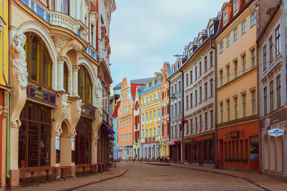 Historic Old Town street in Riga with colorful Renaissance buildings, ornate architecture, and cobblestone pedestrian walkway