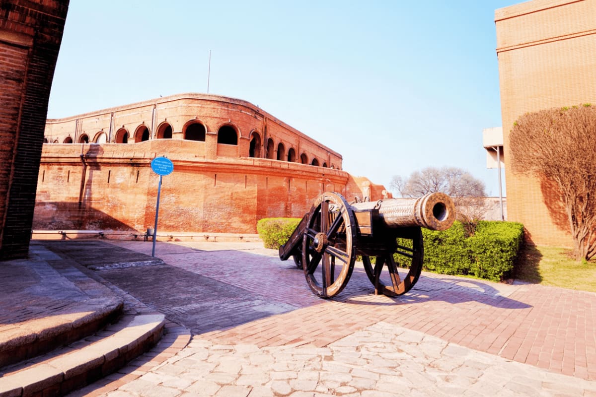 Historic red brick fort with cannon display at Fort Aguada military monument in Goa
