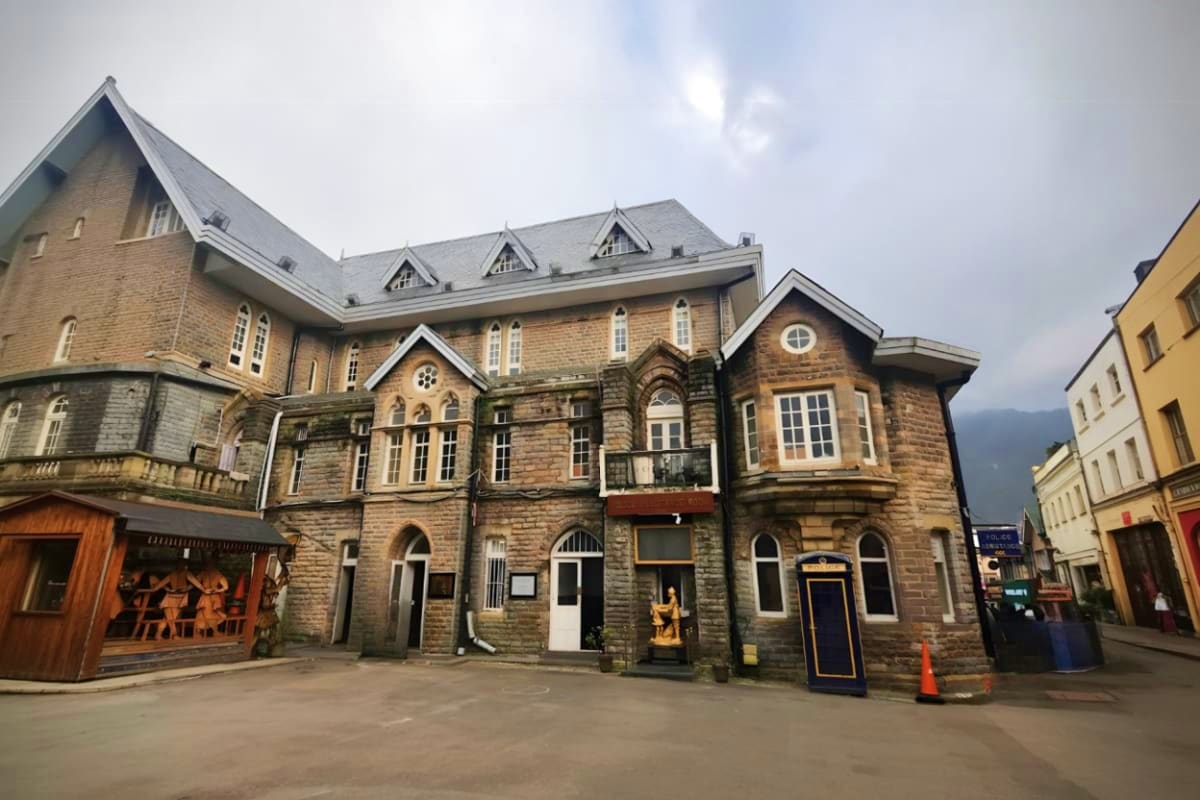 Historic stone building with steep pitched roof and dormer windows in traditional European mountain town architecture