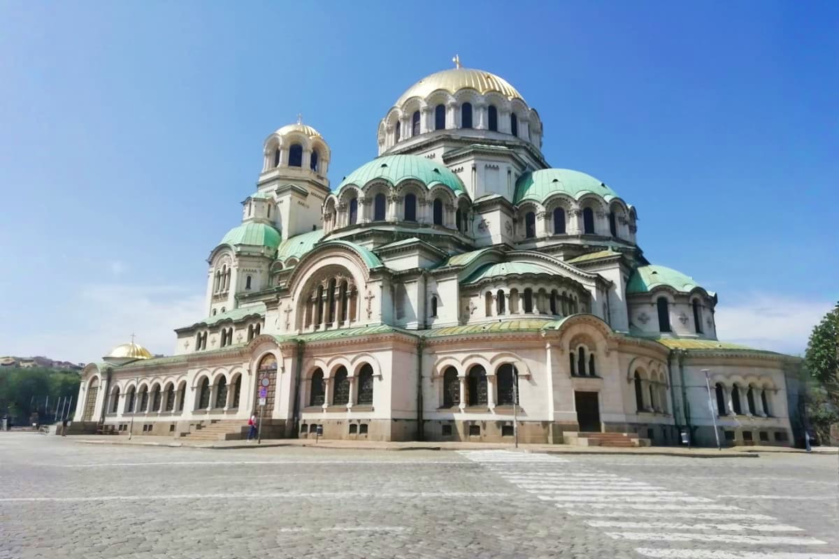 Alexander Nevsky Cathedral in Sofia, Bulgaria with golden domes and white stone architecture against blue sky