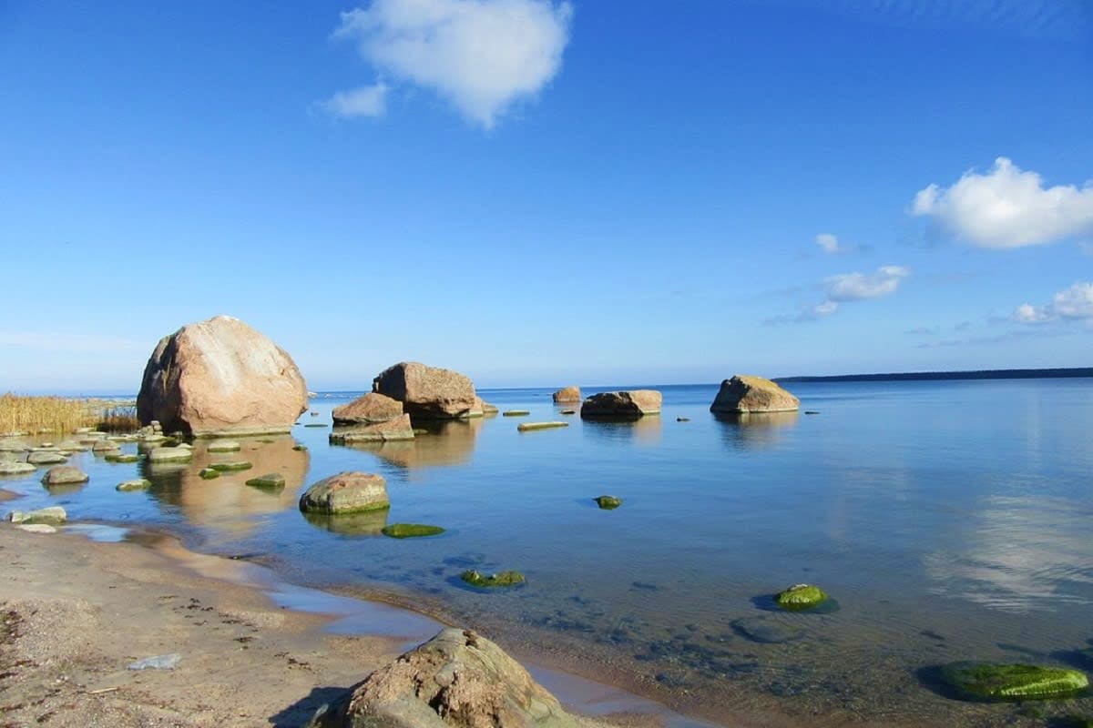 Ultimate Tallinn & Nature Retreat Rocky beach with large boulders and calm blue water under clear sky in Estonia