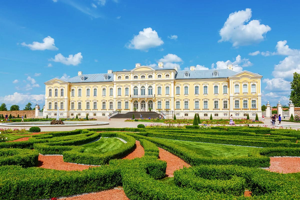 Yellow neoclassical palace with formal hedge garden and blue sky with white clouds, Rundale Palace Latvia