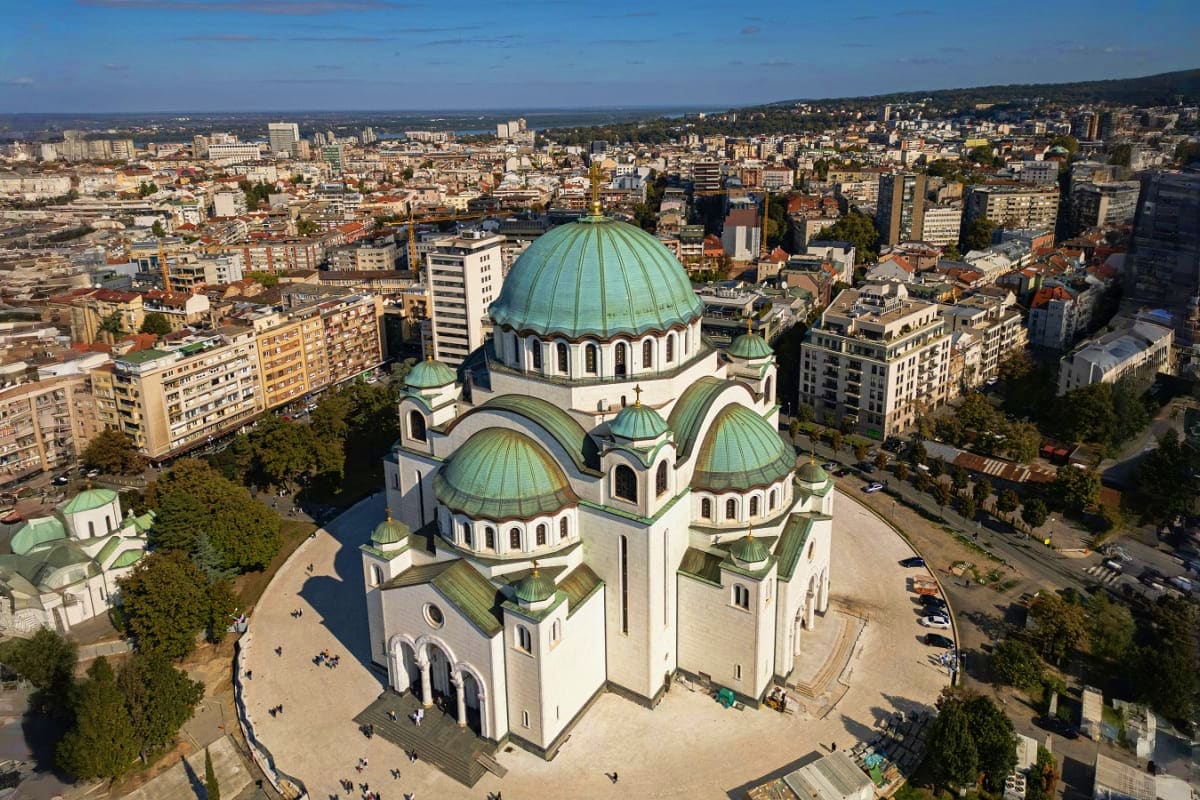 Aerial view of Church of Saint Sava in Belgrade, Serbia surrounded by urban cityscape and green trees
