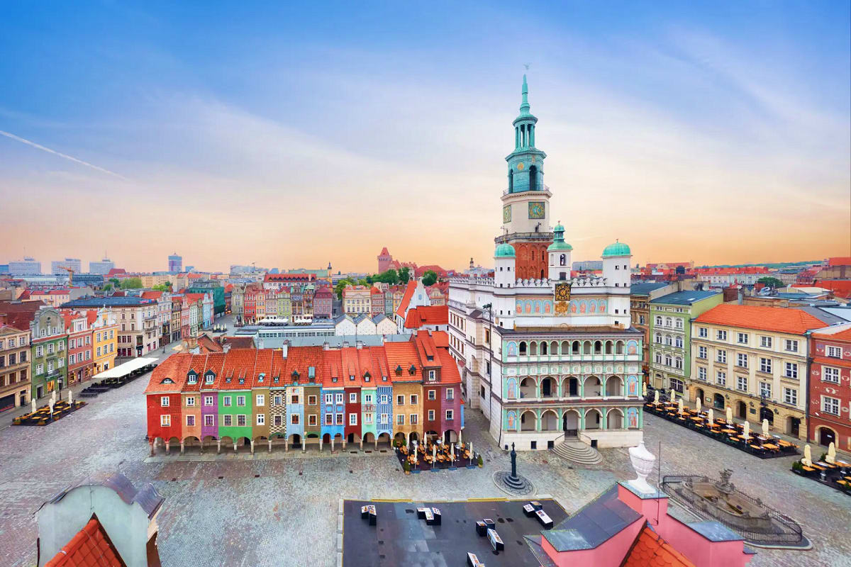 Aerial view of Poznan Old Town square at sunset with colorful Renaissance buildings and Town Hall tower with green cupola in 