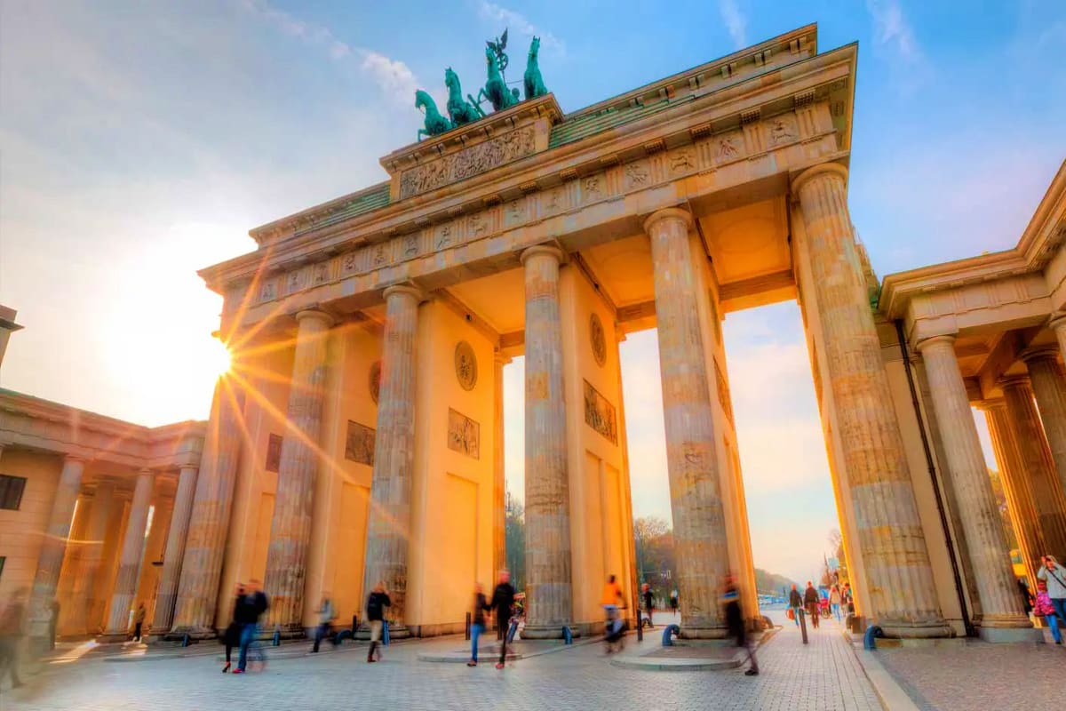 Brandenburg Gate in Berlin at sunset with golden light illuminating the classical columns and green quadriga sculpture on top