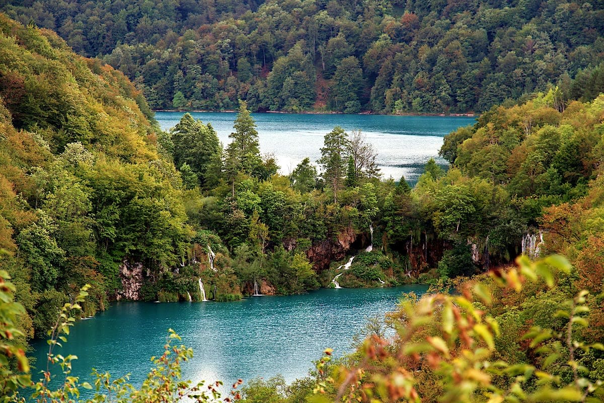 Turquoise lakes surrounded by dense forests and cascading waterfalls in Plitvice Lakes National Park, Croatia