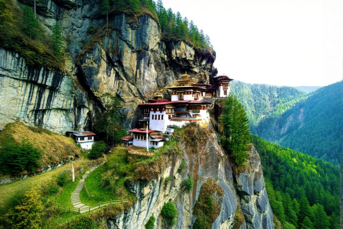 Tiger's Nest Monastery perched on a steep cliff face surrounded by forested mountains in Bhutan's Paro Valley
