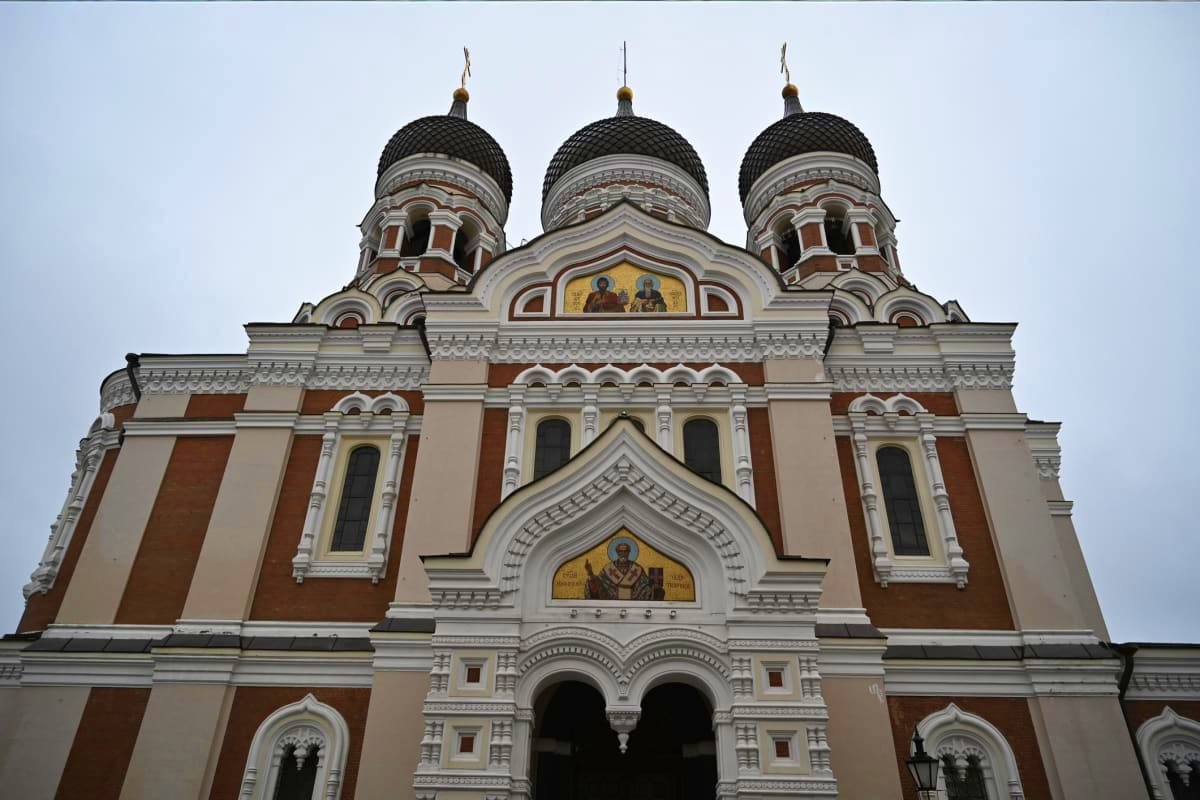 Alexander Nevsky Cathedral in Tallinn with three golden domes and ornate Russian Orthodox architecture, red brick and white s