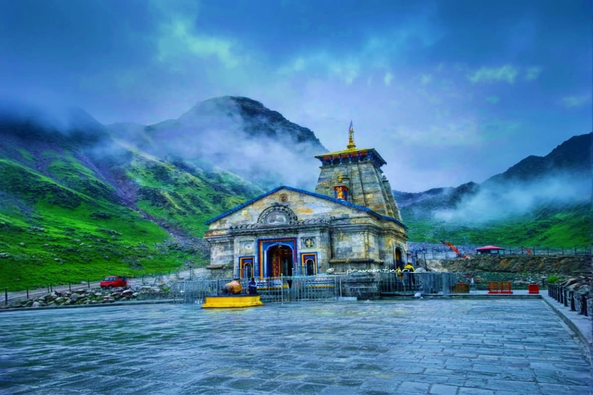 Ancient Hindu temple with golden spire nestled in misty green mountain valley during Do Dham Yatra pilgrimage