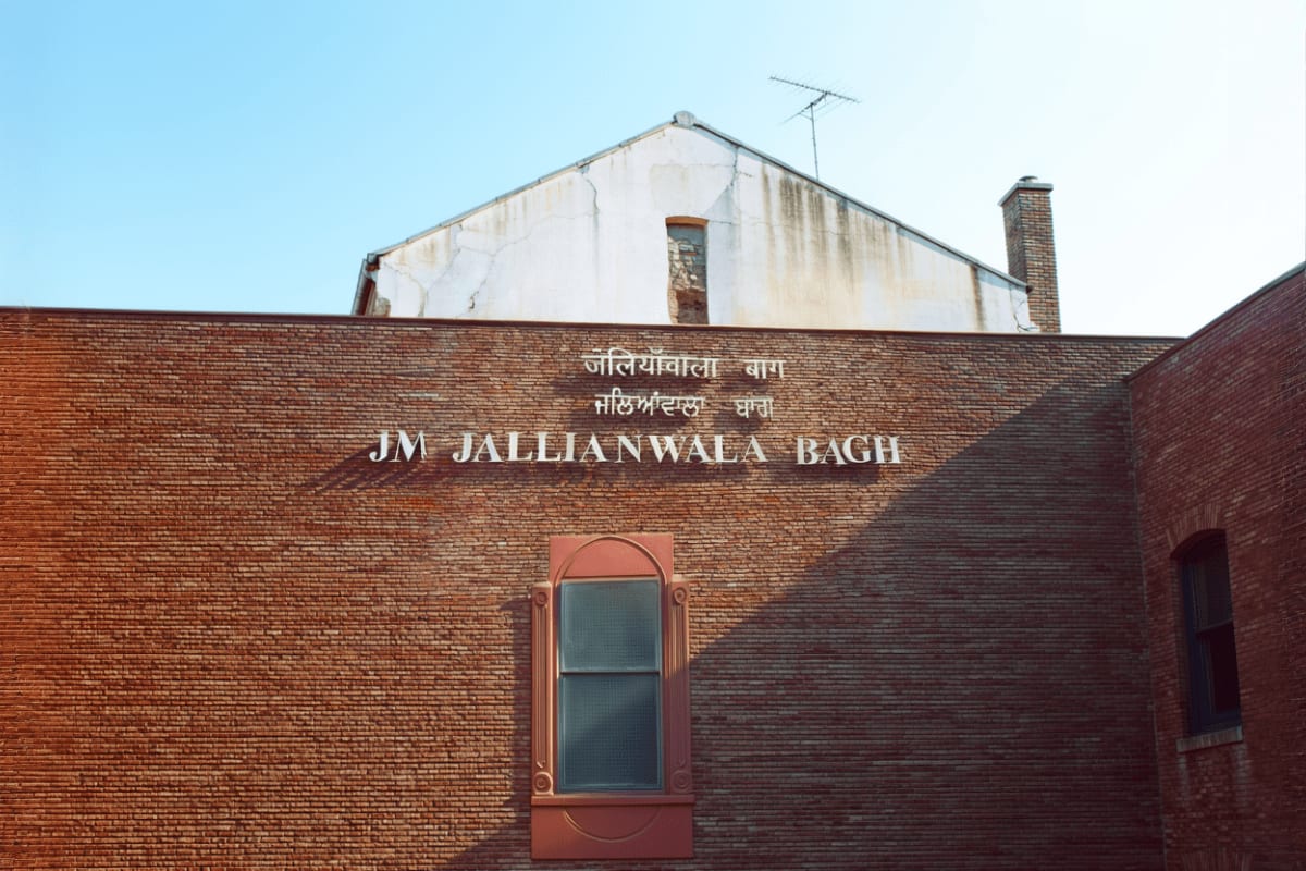 Best of Himachal with Amritsar from Dharamshala Dalhousie and Golden Temple Jallianwala Bagh memorial in Amritsar with brick wall, arched doorway, and text signage in English and Punjabi script