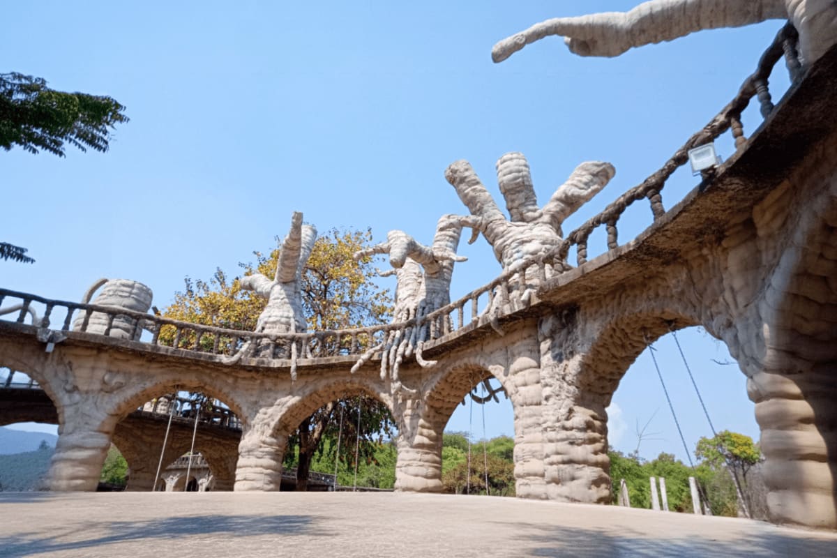 Stone elephant statue bridge with carved tusks and trunk at Himachal Pradesh wildlife sanctuary overlooking forested valley l