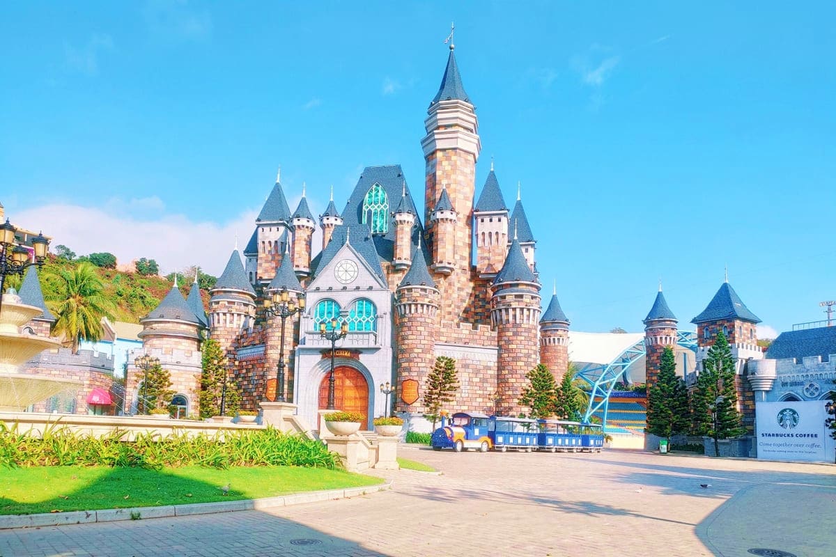Fairy-tale castle with turrets and spires at Phu Quoc amusement park under clear blue sky
