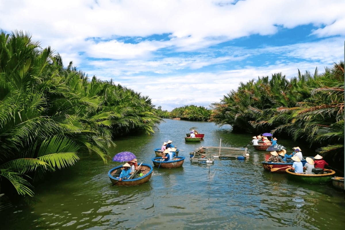 Traditional wooden boats with tourists on a river surrounded by palm trees in Phu Quoc, Vietnam