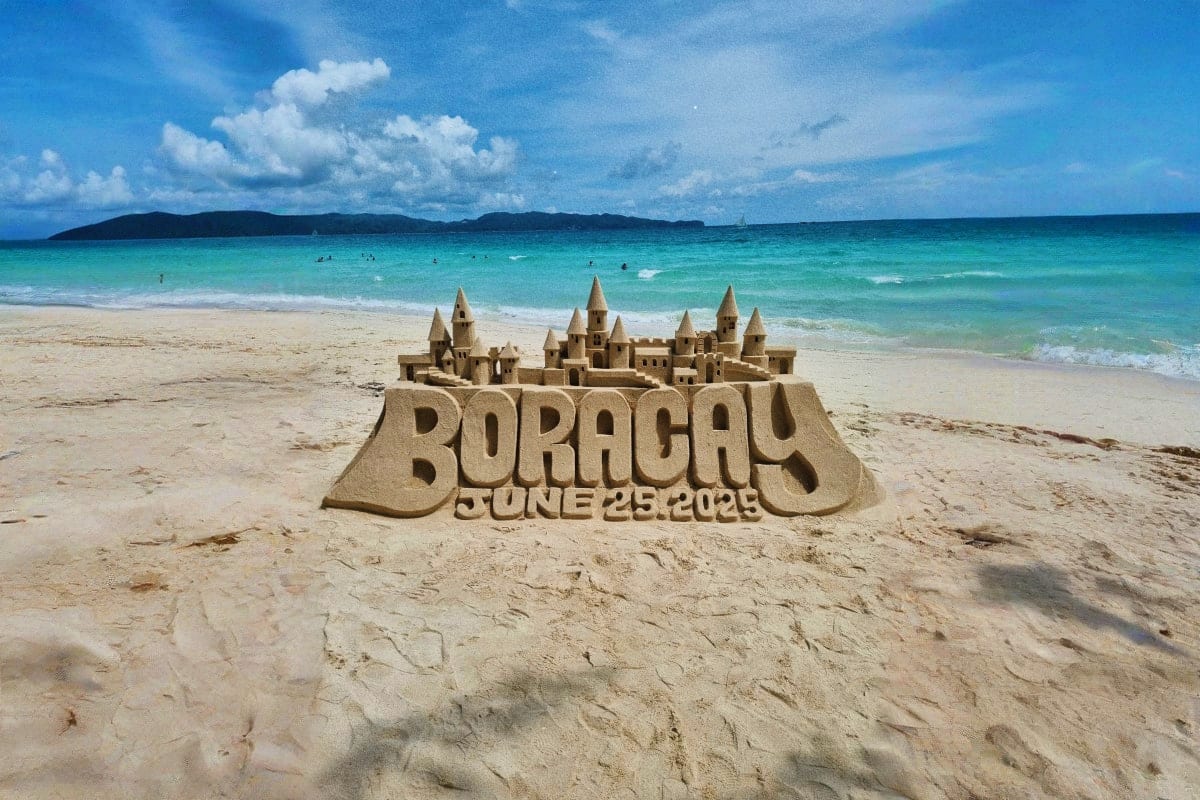 Best of Manila and Boracay Tour Package Elaborate sand castle with multiple towers on Boracay beach with turquoise ocean and island in background