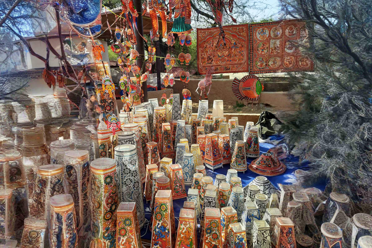 Traditional Armenian handicrafts display featuring decorated ceramic vessels, ornaments, and painted panels at an outdoor mar