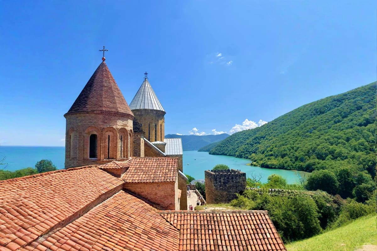 Akdamar Church with red-tiled roofs overlooking turquoise lake surrounded by green mountains in Georgia