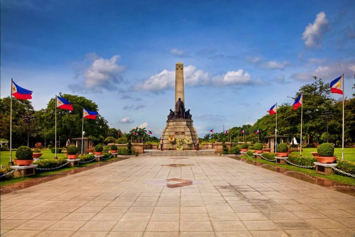 Manila Wellness Retreat Rizal Monument in Manila with Philippine flags and manicured gardens under blue sky