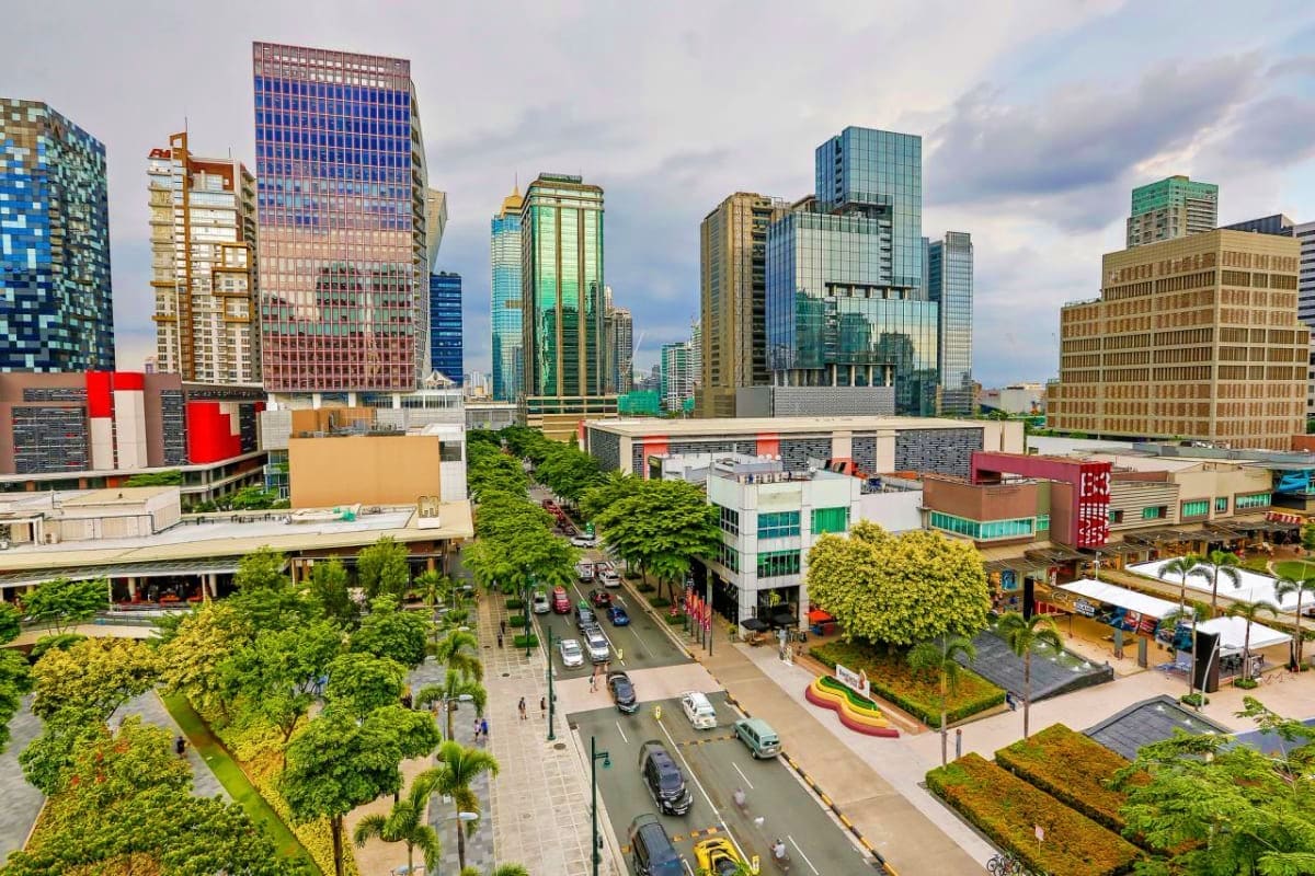 Pristine Palawan Tour Urban downtown skyline with modern high-rise buildings, street level with trees and pedestrians, daytime cityscape view