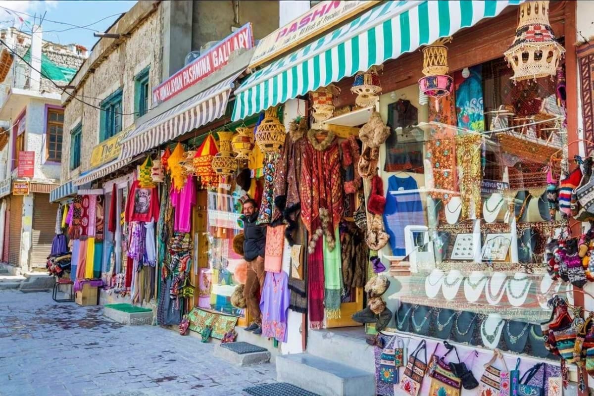 Colorful traditional market street in Kashmir with vendor stalls displaying textiles, handicrafts, lanterns and souvenirs und