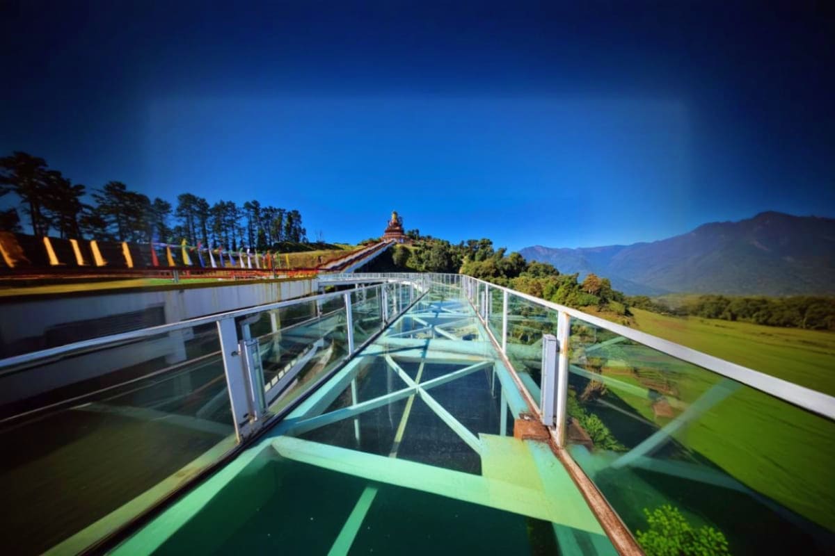 Glass walkway with mountain views at Namchi's scenic overlook, surrounded by green valleys and Himalayan peaks in Sikkim