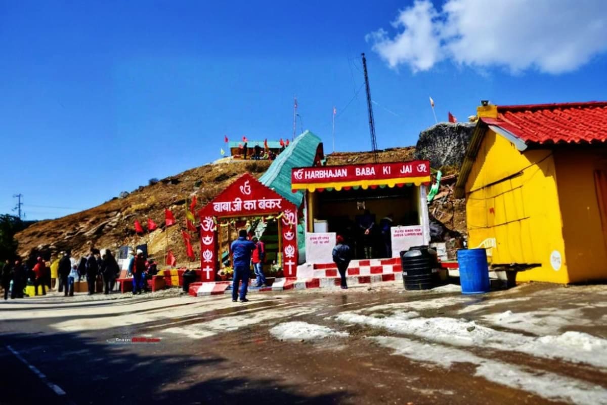 Harbhajan Baba Ki Jai temple entrance with colorful red and yellow structures at high altitude mountain shrine in Sikkim