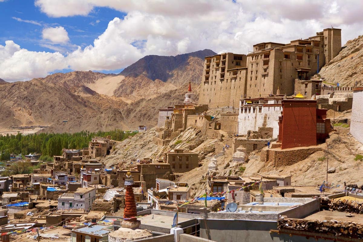 Lamayuru Monastery perched on rocky hillside in Ladakh with desert mountains and traditional stone buildings in background