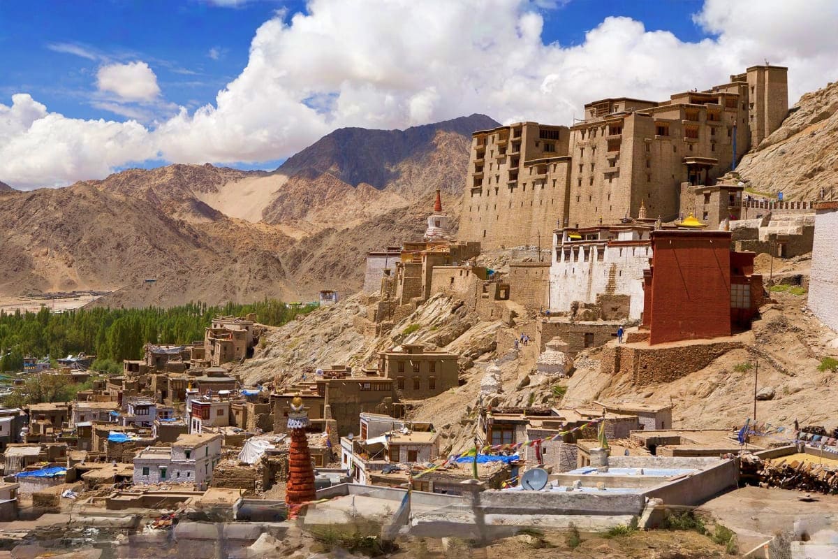 Leh Palace and traditional architecture overlooking Leh town with arid Himalayan mountains and blue sky in Ladakh