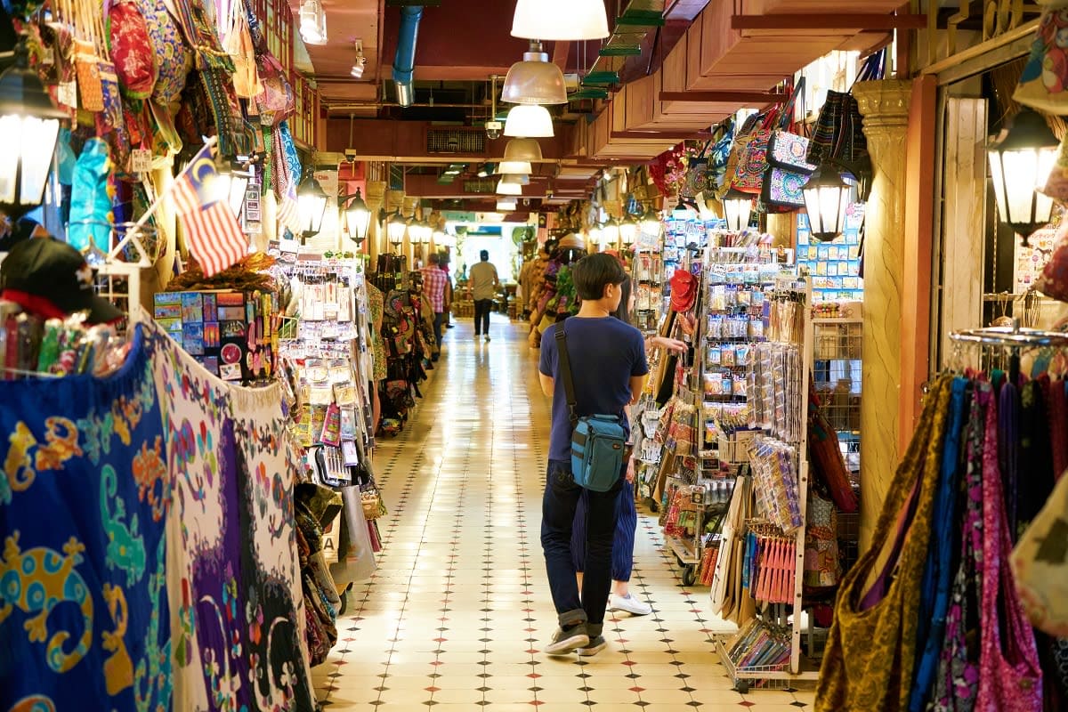Traditional Uzbek bazaar with colorful fabrics, textiles, and souvenirs displayed in covered market stalls and hanging mercha