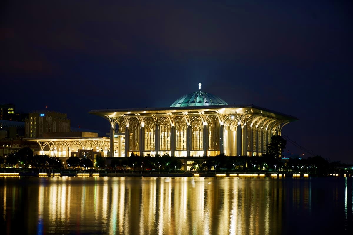 Illuminated Tashkent Palace of Forums reflected in river at night, iconic Uzbekistan landmark