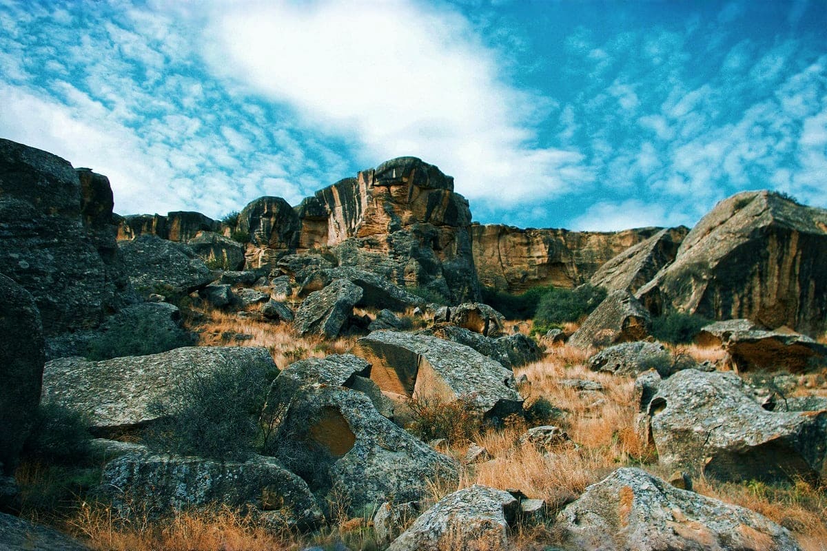 Rocky mountain landscape with distinctive stone formations and desert vegetation under blue sky in Gabala, Azerbaijan